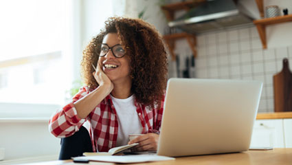 Woman looking away from laptop