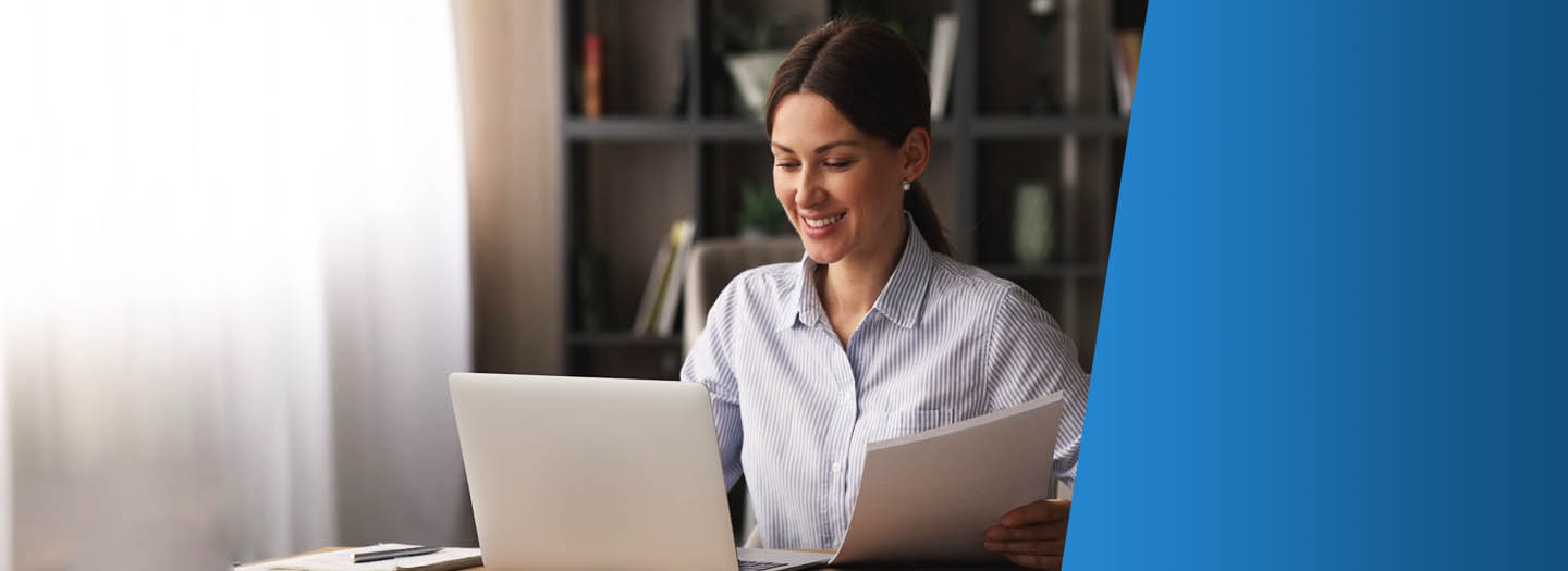 Woman sitting at desk on laptop reviewing documents