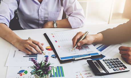 Two people looking over charts and figures