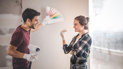 Young couple selecting paint samples on wall