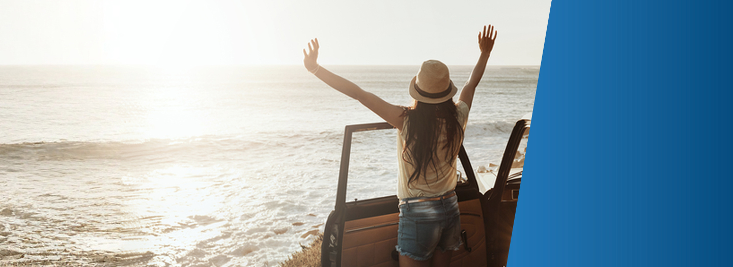 woman watching the sunset at the beach from her car