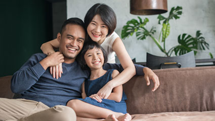 Family sitting on couch smiling