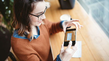 Woman taking photo of check with Smartphone