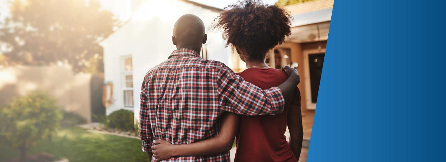 couple standing in front of their new home