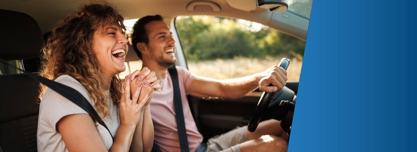 2 people laughing while driving a car