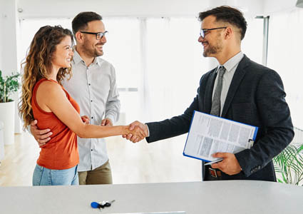 Couple shaking hands with a lending representative