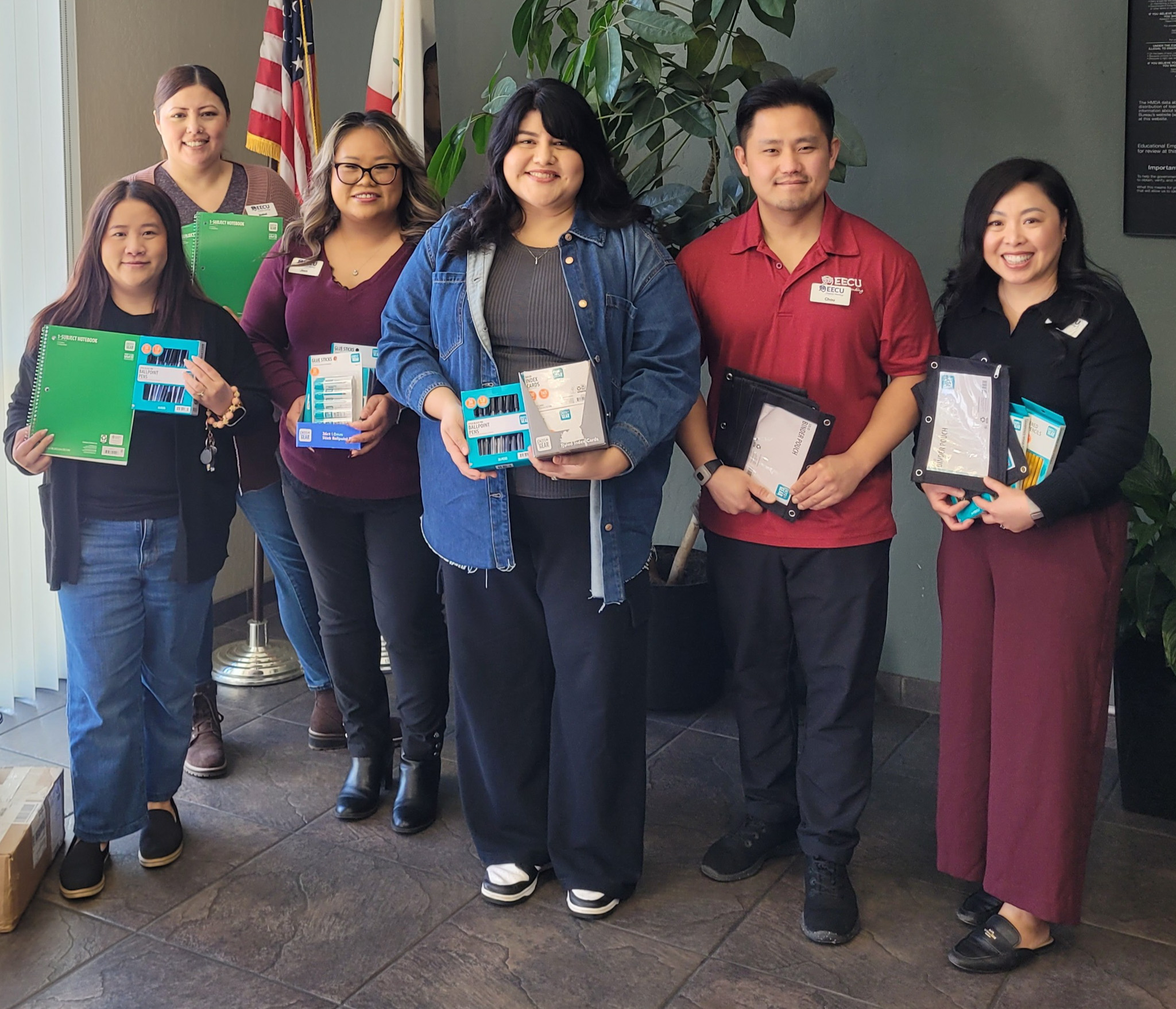 EECU Branch representatives holding school supplies that are being donated.